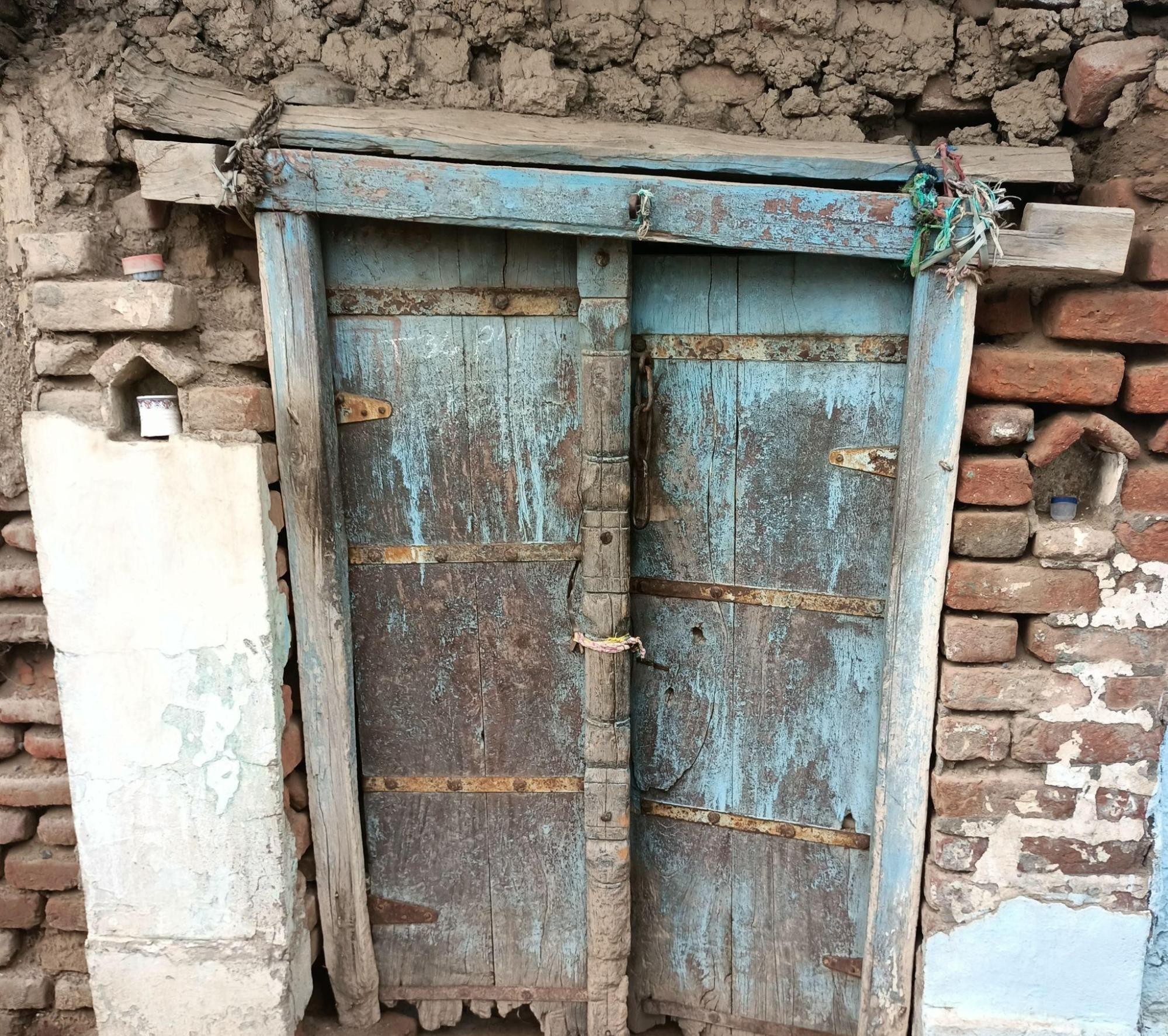Similar double-doored design with faded blue paint, sharing construction features with the documented Malipura residence, indicating a local door framing style. (Source: CKA Archives)