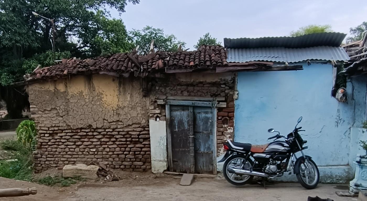 The traditional clay tile roofing (Mangalore tiles) over a blue-painted wall and wooden door, showing the layered arrangement of curved tiles. (Source: CKA Archives)