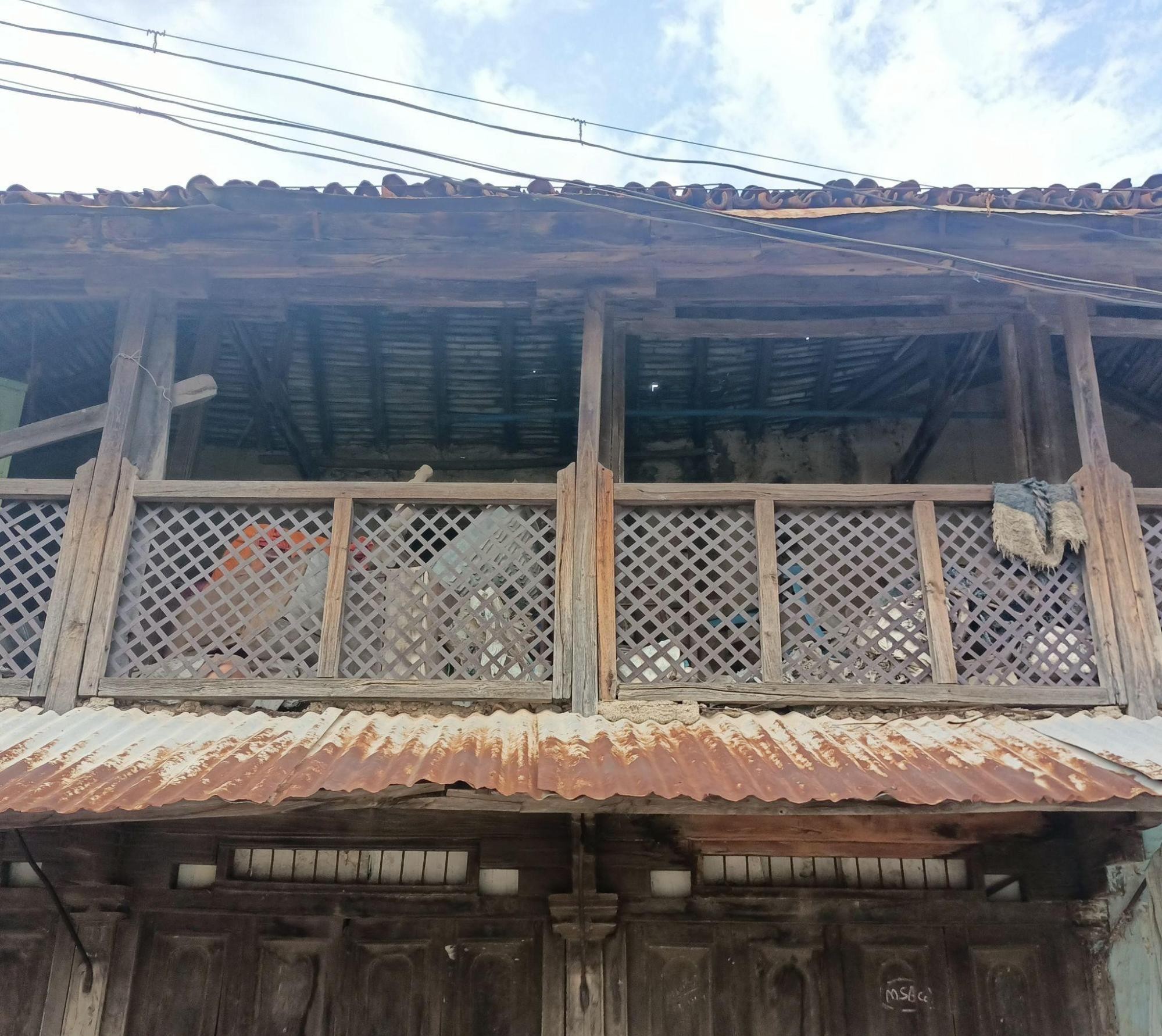 Upper floor wooden railing with latticed panels under sloped roof. (Source: CKA Archives)