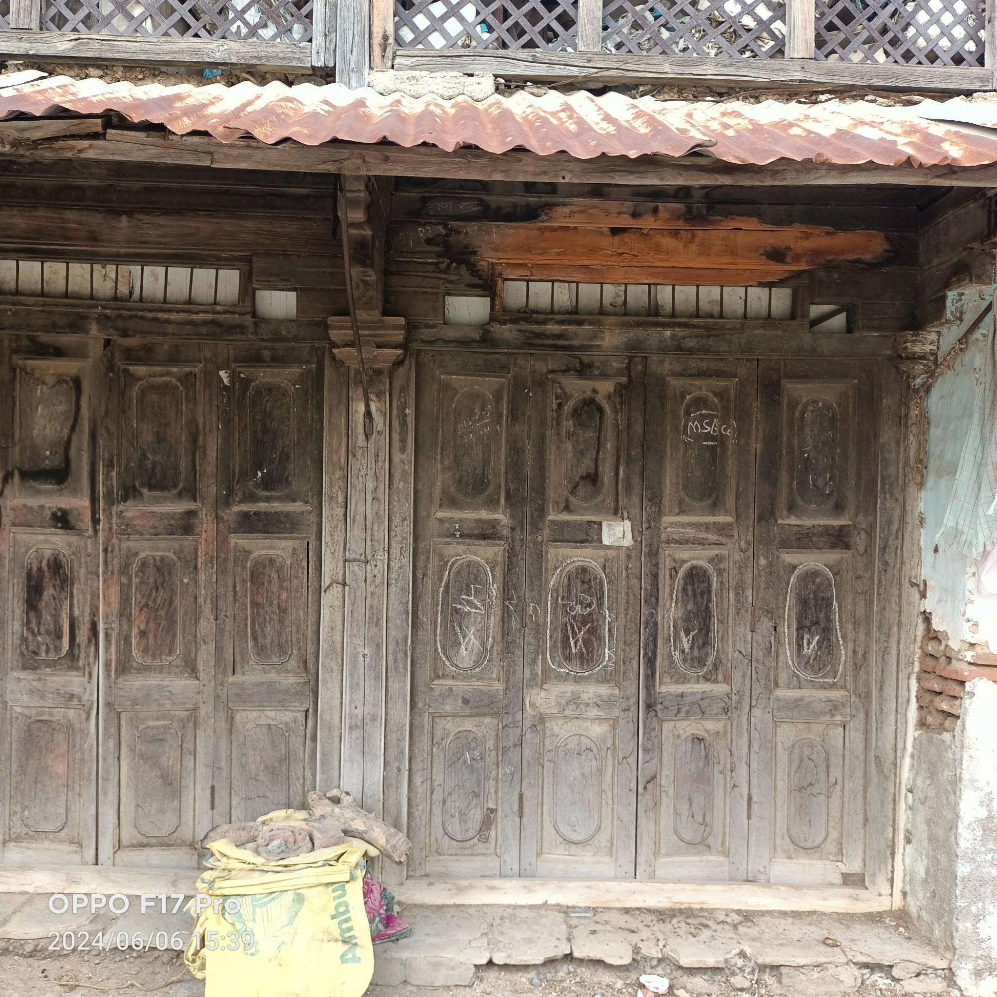 Wider double door with geometric panels, demonstrating the property's distinct wooden facade, where the structure transitions from brick to wood construction. (Source: CKA Archives)
