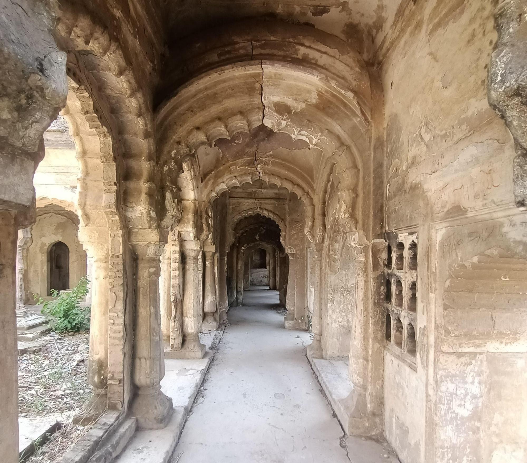 A long corridor featuring repeated arched passages and stone latticework along the walls of Bebah Bagh. (Source: CKA Archives)