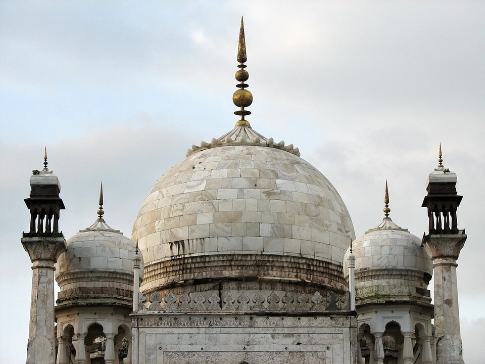 The white marble dome of Bibi Ka Maqbara is flanked by four smaller domes and topped with a brass finial.[12]