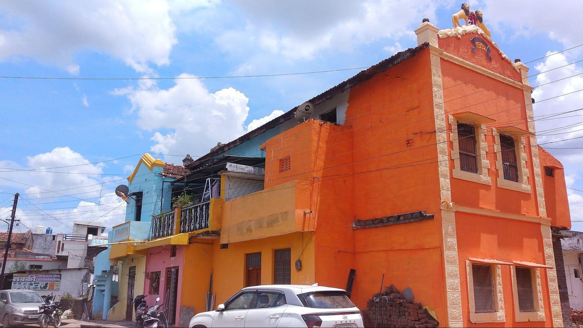 The 1952 residence in Aheri town with its orange exterior, decorative window moldings, and cultural engravings, which locals point out is representative of mid-century regional architecture. (Source: CKA Archives)