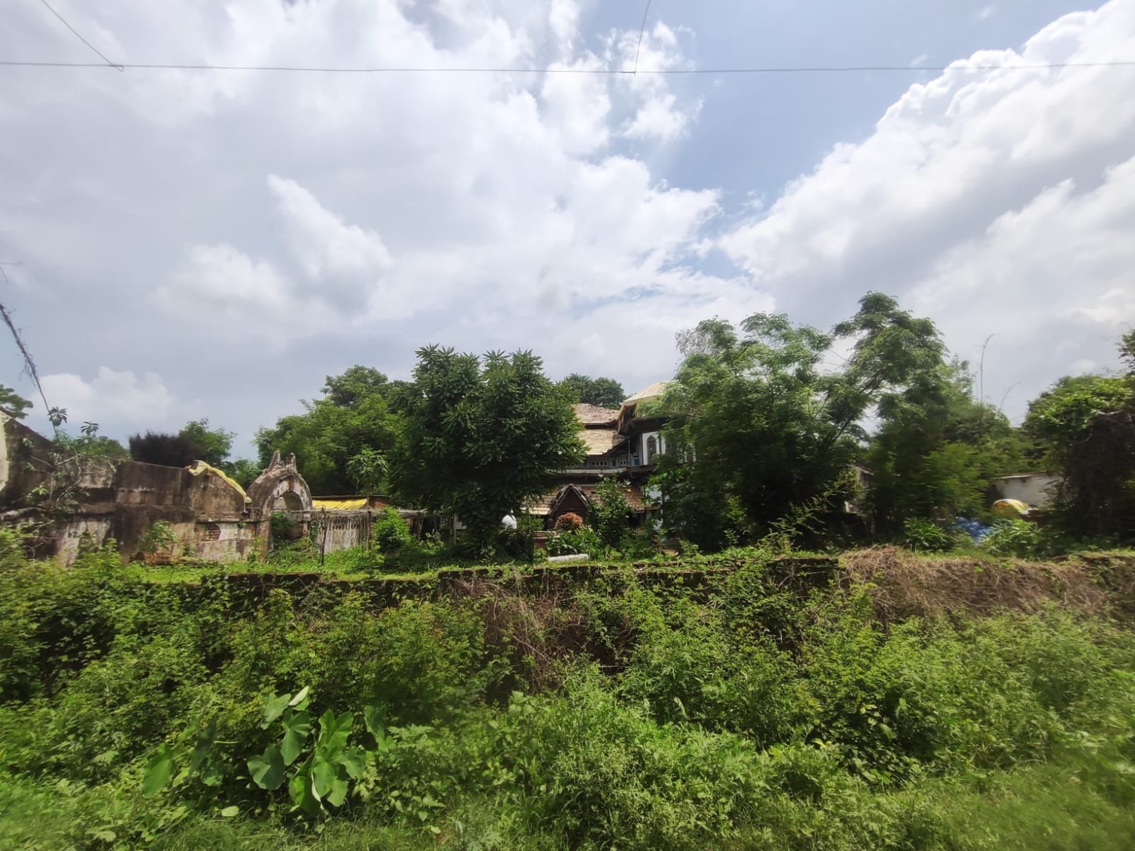 A street view of the Doye Wada. One can see the many arches and the structure of the residence hidden within the trees. (Source: CKA Archives)