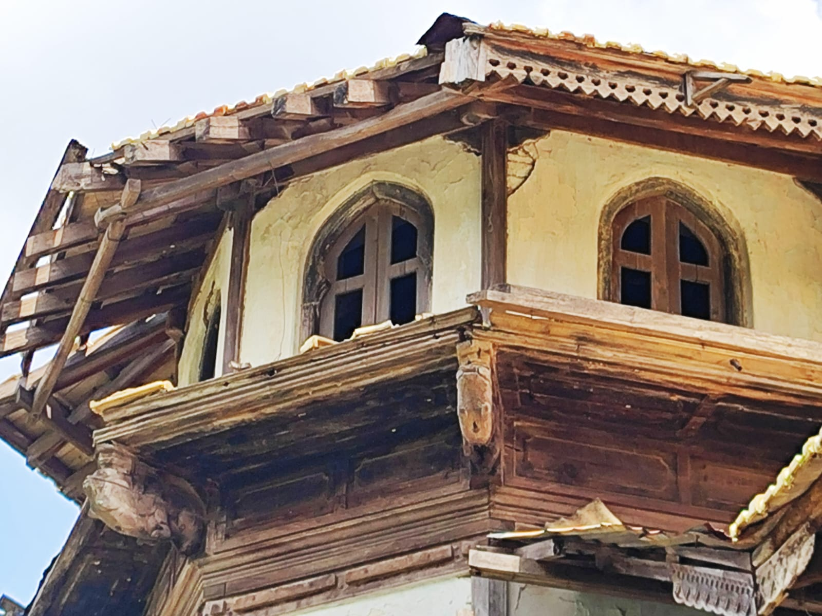 An arched window with plaster surround from Doye Wada featuring a curved, molded arch (cusped arch design). The window contains wooden muntins dividing the glass panes in a traditional pattern. (Source: CKA Archives)