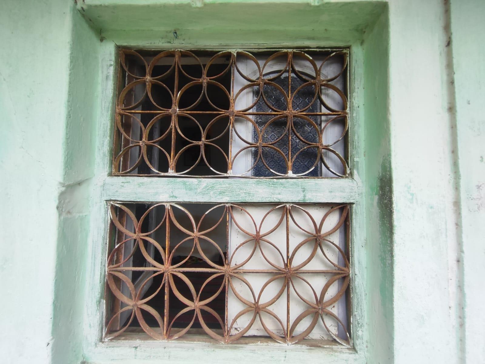 The windows of the house are compact in size. They are protected by metal grills with a distinctive floral pattern; which were likely added during the renovations. (Source: CKA Archives)