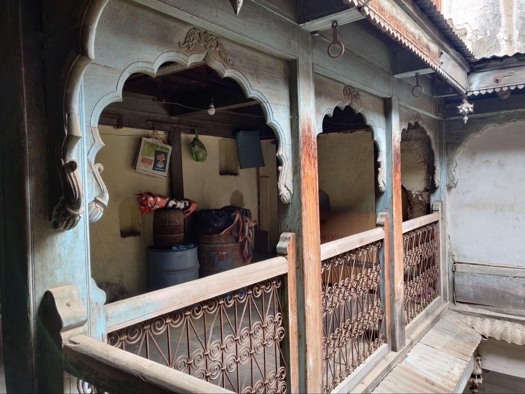 A close-up of the railing shows decorative metal grills paired with a carved wooden top rail. (Source: CKA Archives)