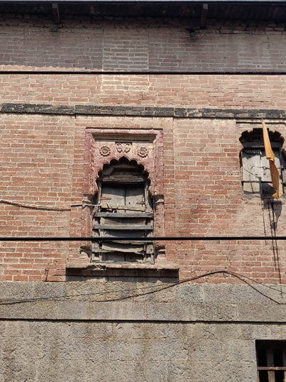 First-floor window with decorative brickwork arches and ornamental details above the wooden frame. (Source: CKA Archives)