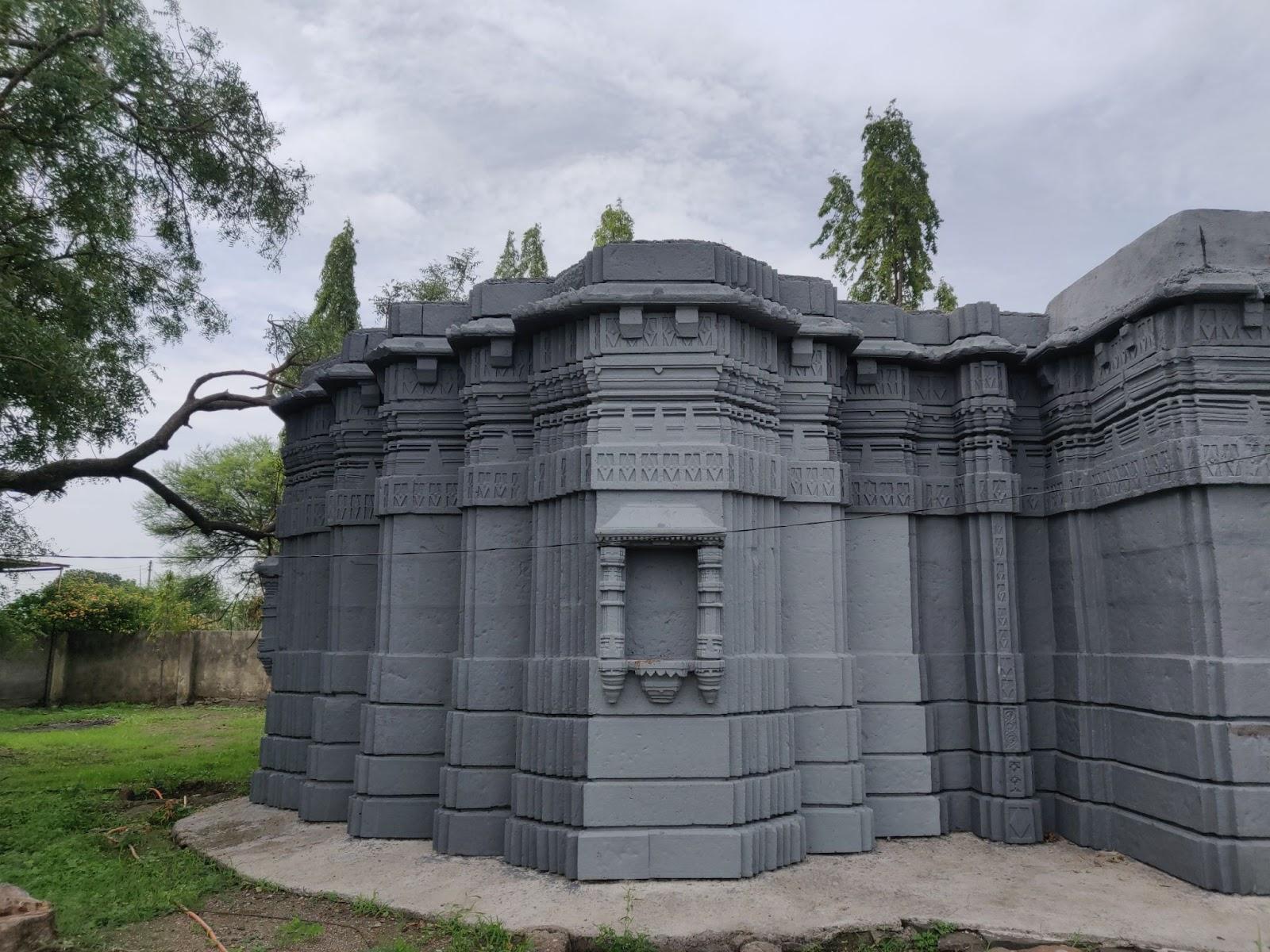 Side view of the Mandir, highlighting carved stone layers and original structure.