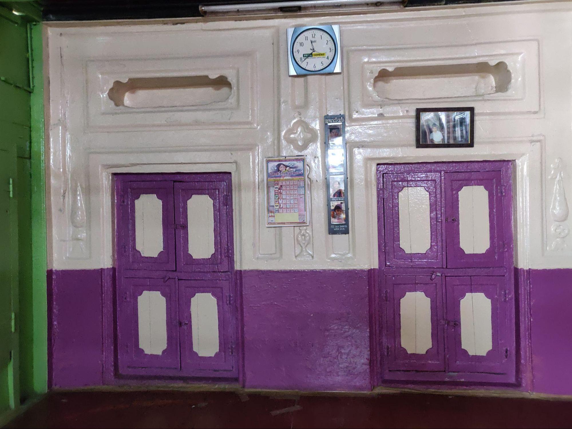 Storage spaces are recessed into the wall and highlighted with a vibrant color. They feature wooden double-shuttered doors with a distinctive design. (Source: CKA Archives)