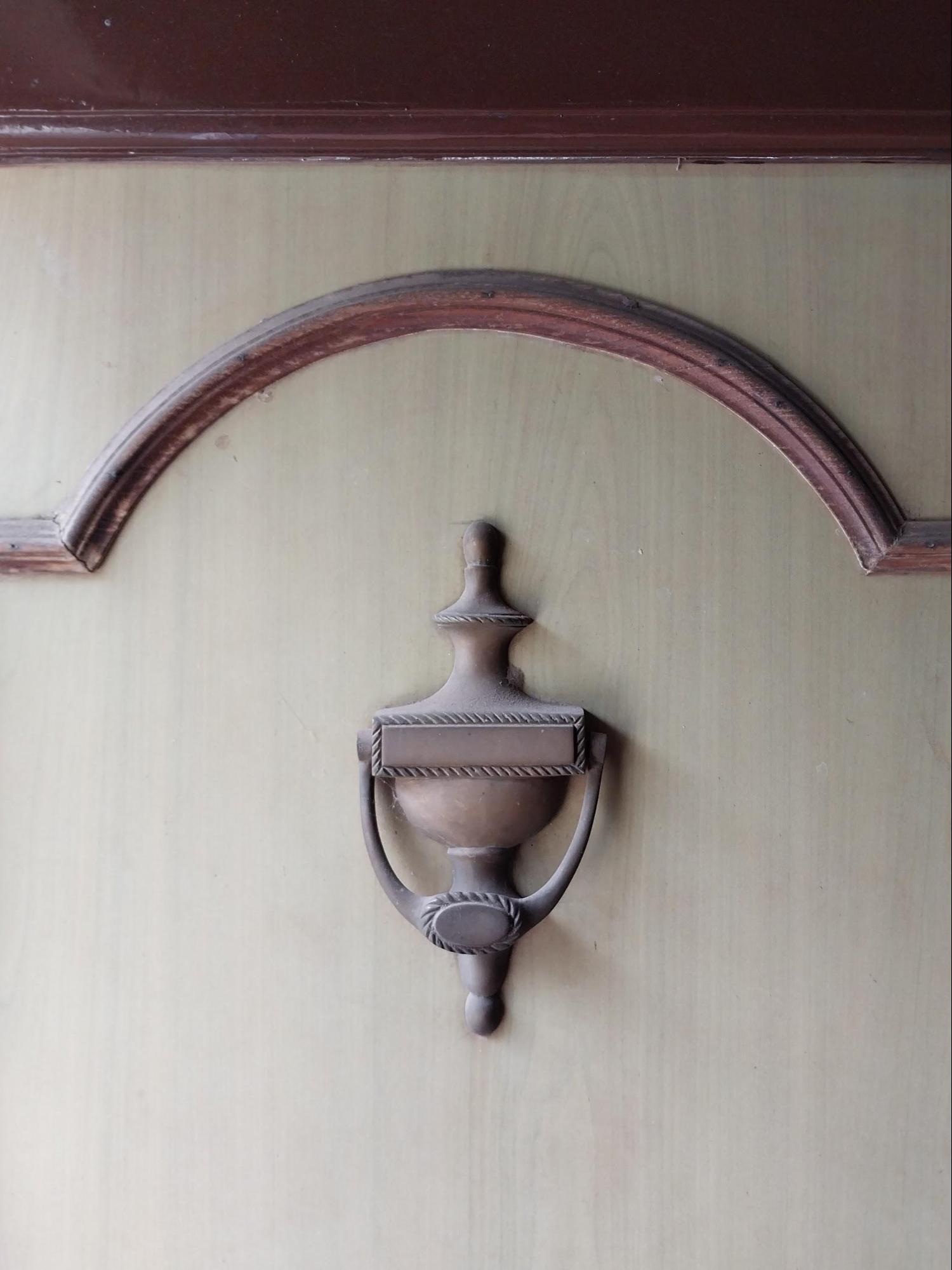 A decorative door knocker on the kitchen door that opens to the backyard shows attention to small functional details. (Source: CKA Archives)