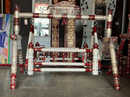 A jhula made from wood and painted over with shades of white and red. Notably, Jhulas like these are built to be placed alongside or inside mandirs and even at homes for babies. (Source: CKA Archives)