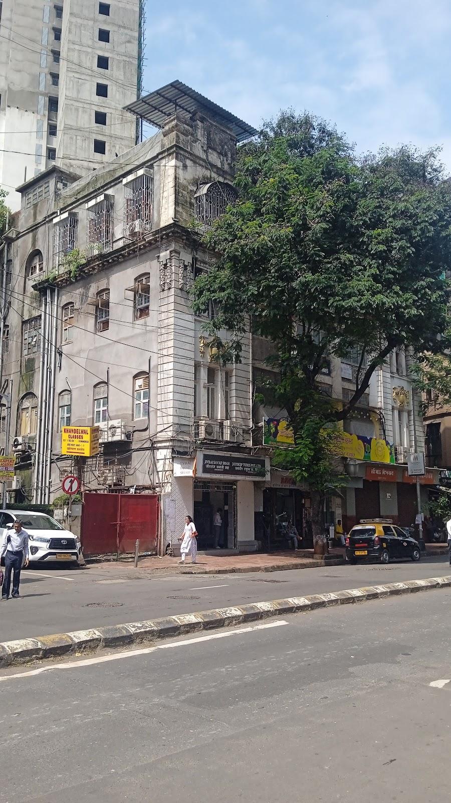 A mixed-use building from the early 20th century featuring commercial shops on the bottom storey and residences above. It is situated on the Sardar Vallabhbhai Patel road leading to Girgaon Chowpatty. Source: CKA Archives