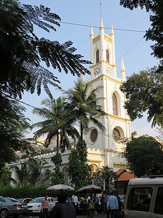 Arched windows and a white façade reflect the Neo-Classical and Neo-Gothic blend of St. Thomas Cathedral in Fort, Mumbai.[3]