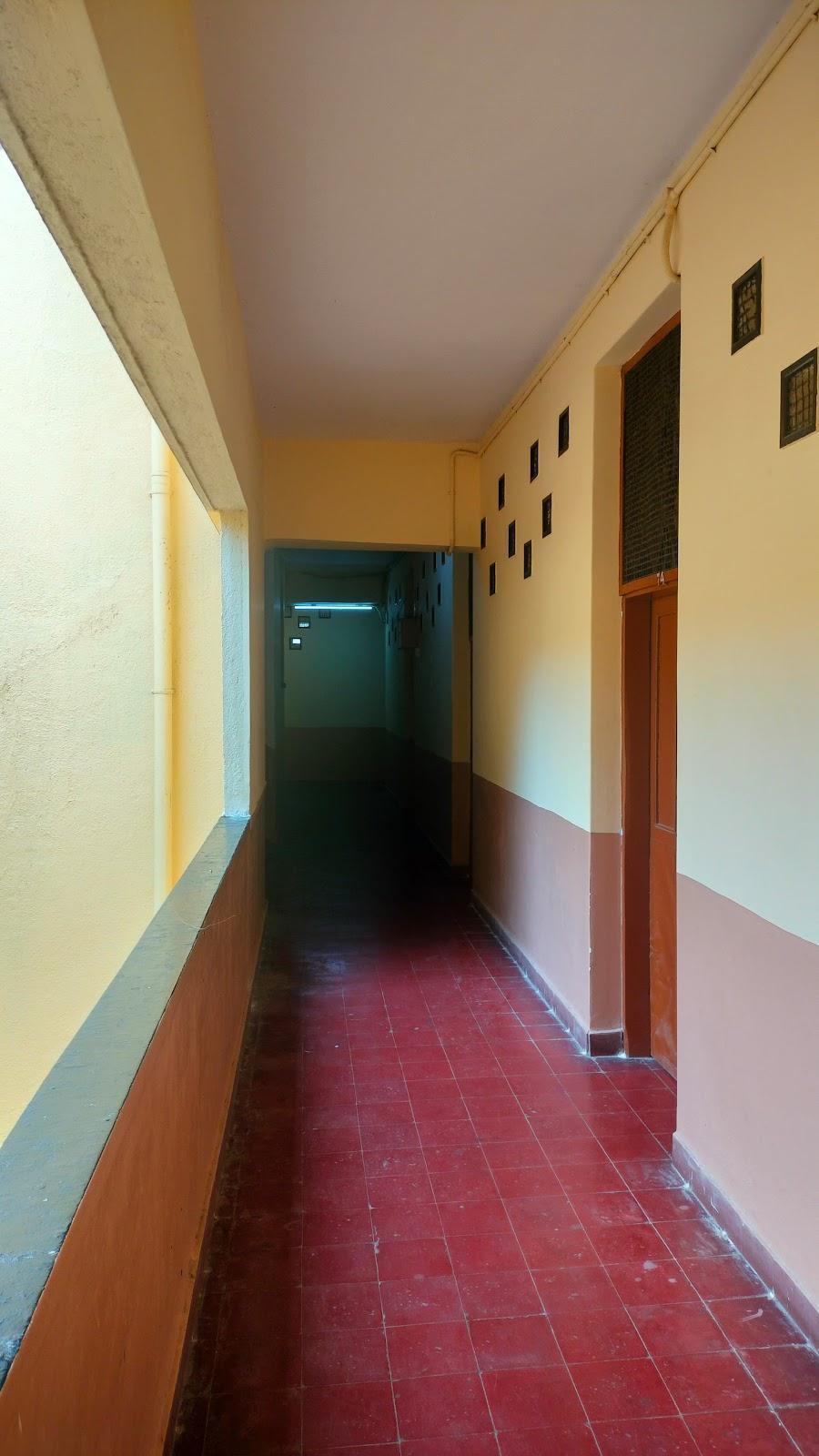 Brick-red tiled passageway that connects each room. Notice the upper clerestory windows that create a funnel effect for air circulation. Source: CKA Archives
