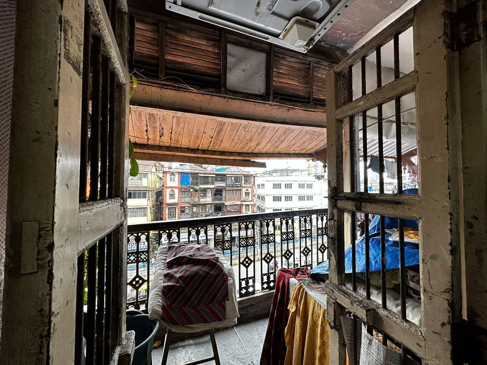 Outer passage that doubles as a shared balcony, enclosed by cast iron parapets within a wooden frame. Source: CKA Archives