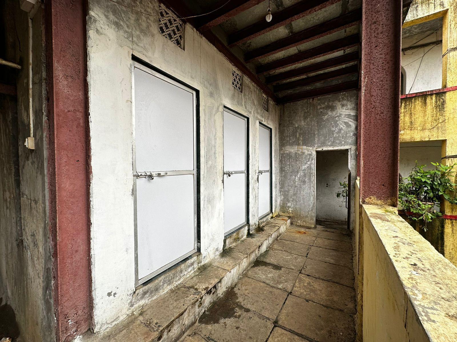 Shared toilets and baths near the staircase featuring PVC doors with aluminum frames and clerestory windows. Source: CKA Archives