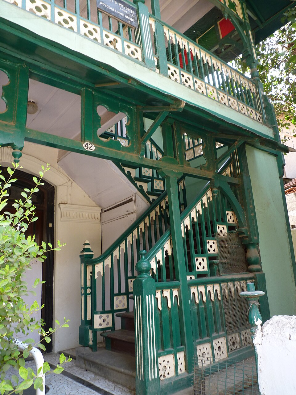 Vibrant green external staircase in Khotachiwadi with timber railings, connecting directly to the upper floor verandah.[22]