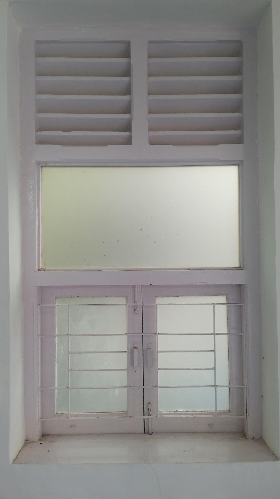 Window with wooden shutters and glass panes which open outwards and metal grills. Notice the glass pane directly above the window and the louvered openings above it. Source: CKA Archives