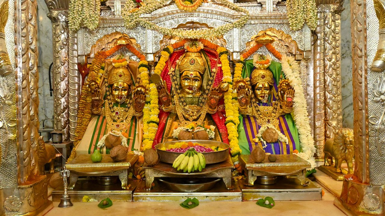 The central shrine of Mahalakshmi Mandir houses the the Tridevi, Mahakali, Mahalakshmi, and Mahasaraswati, each richly adorned in traditional gold jewelry.[20]