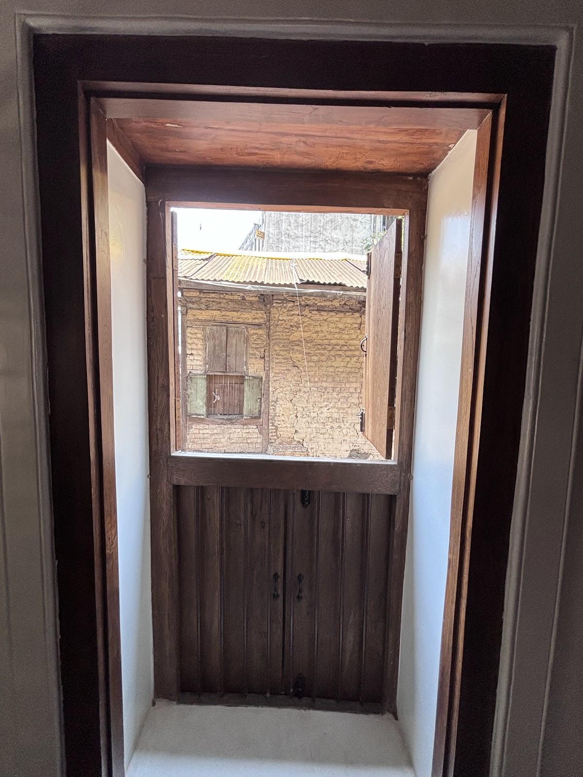 Box windows on the third storey featuring double-door shutters in the top half that open outward and metal railings enclosing the bottom half. (Source: CKA Archives)