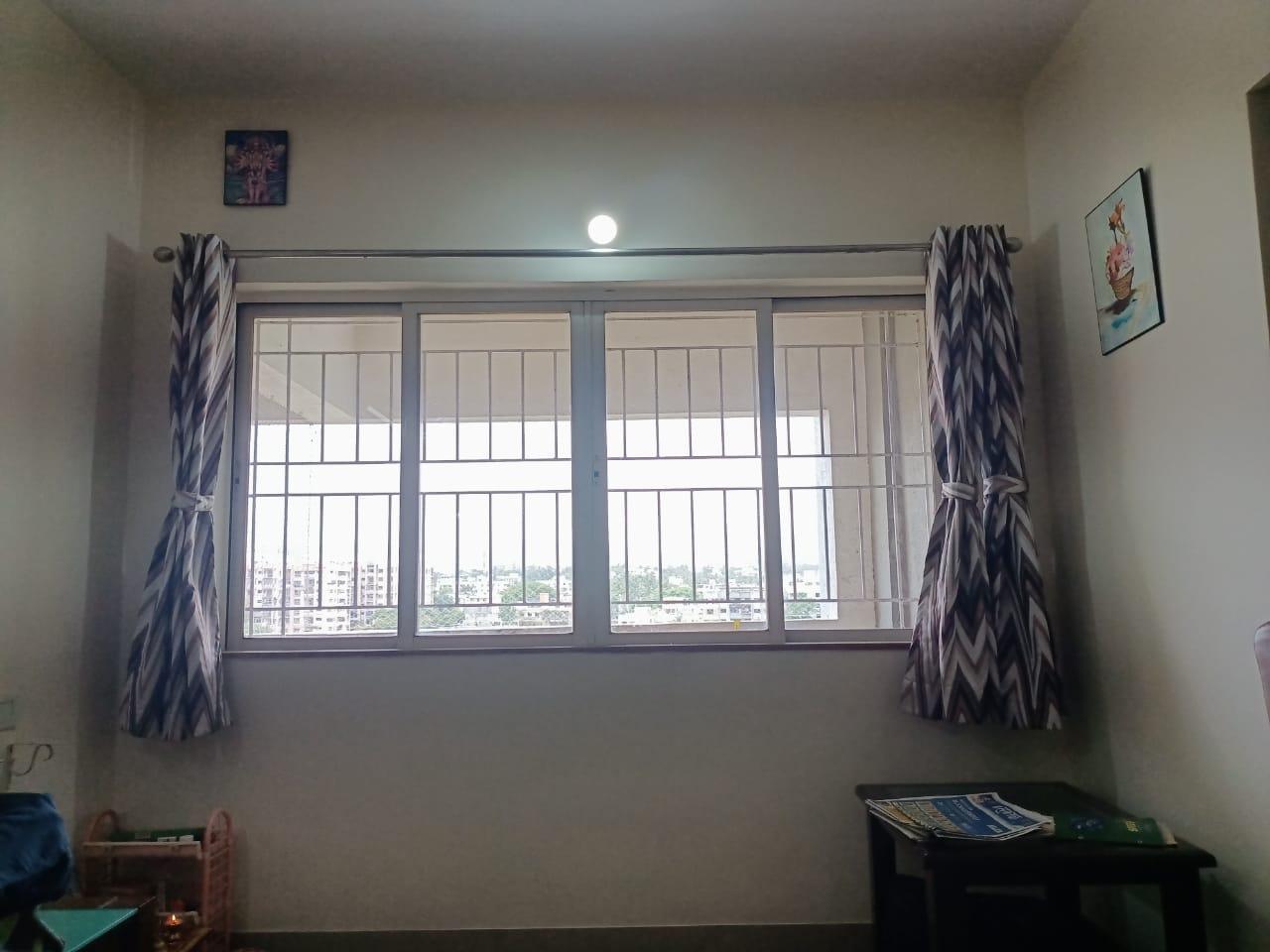 Rectangular window featuring sliding glass shutters and metal grills. (Source: CKA Archives)