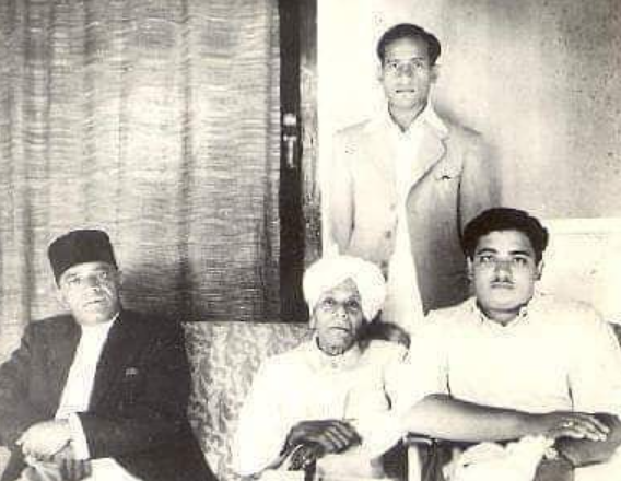 An aged Sawai Gandharva (center) with a young Bhimsen Joshi standing behind him.[13]