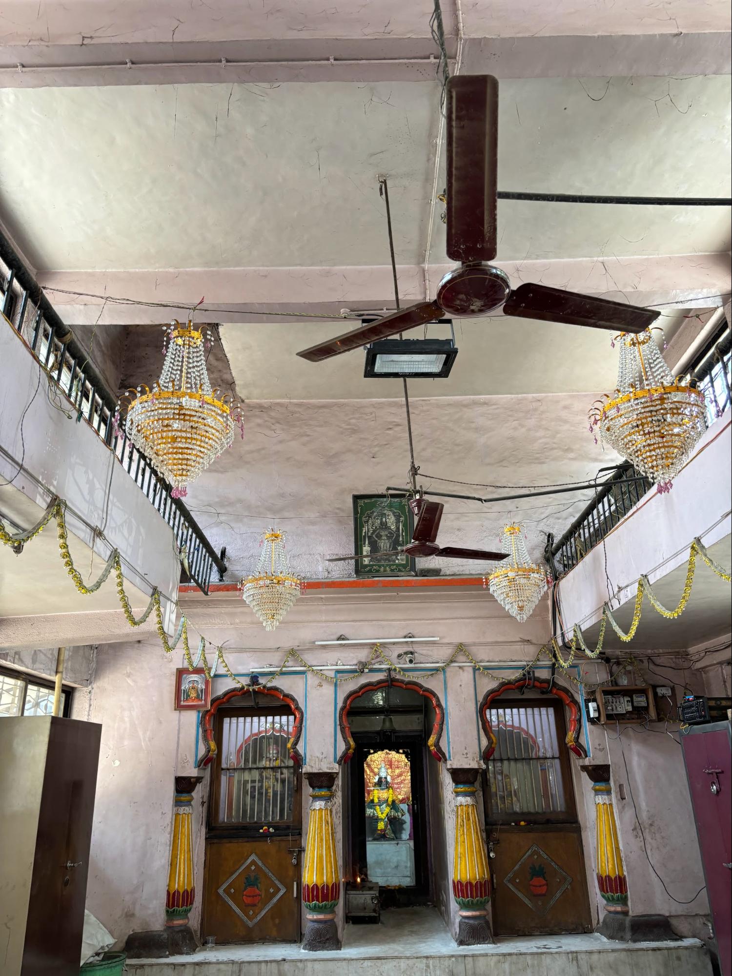 Inside the sabhamandap, a vintage bell still hangs, and glass chandeliers light the space. (Source: CKA Archives)