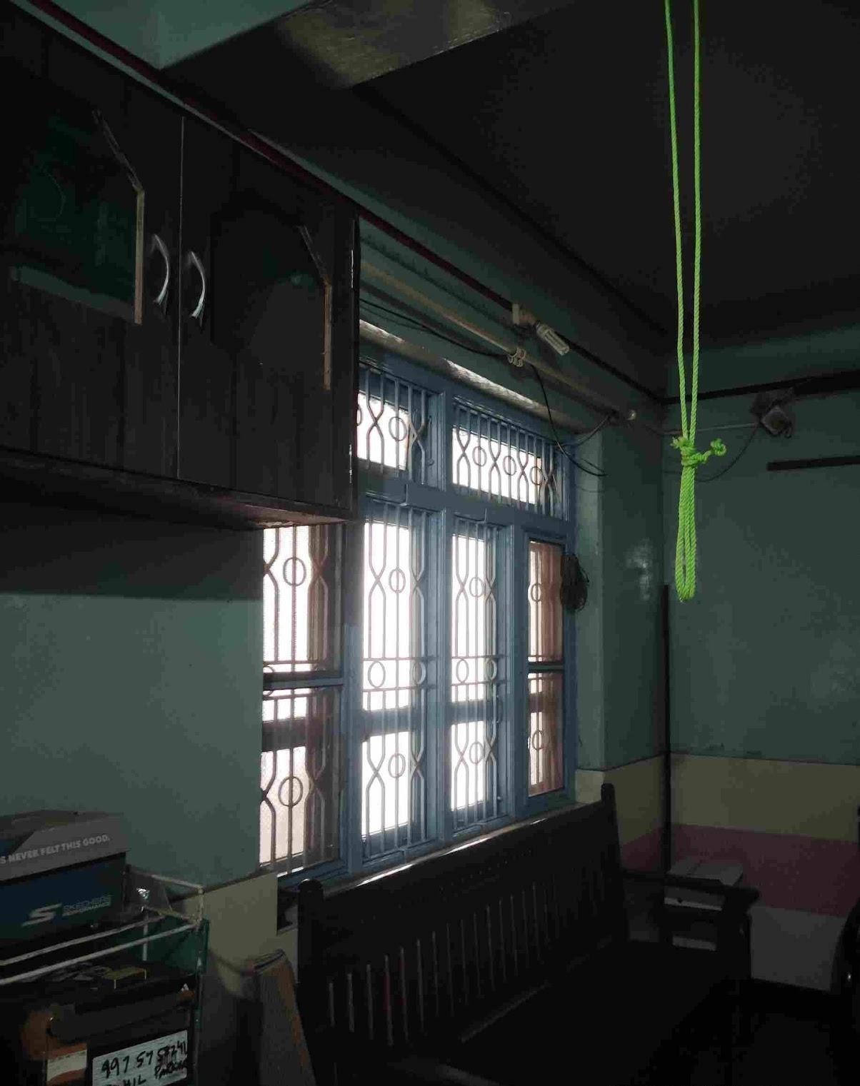 Living room window with a decorative grill design and glass paneled shutters. (Source: CKA Archives)