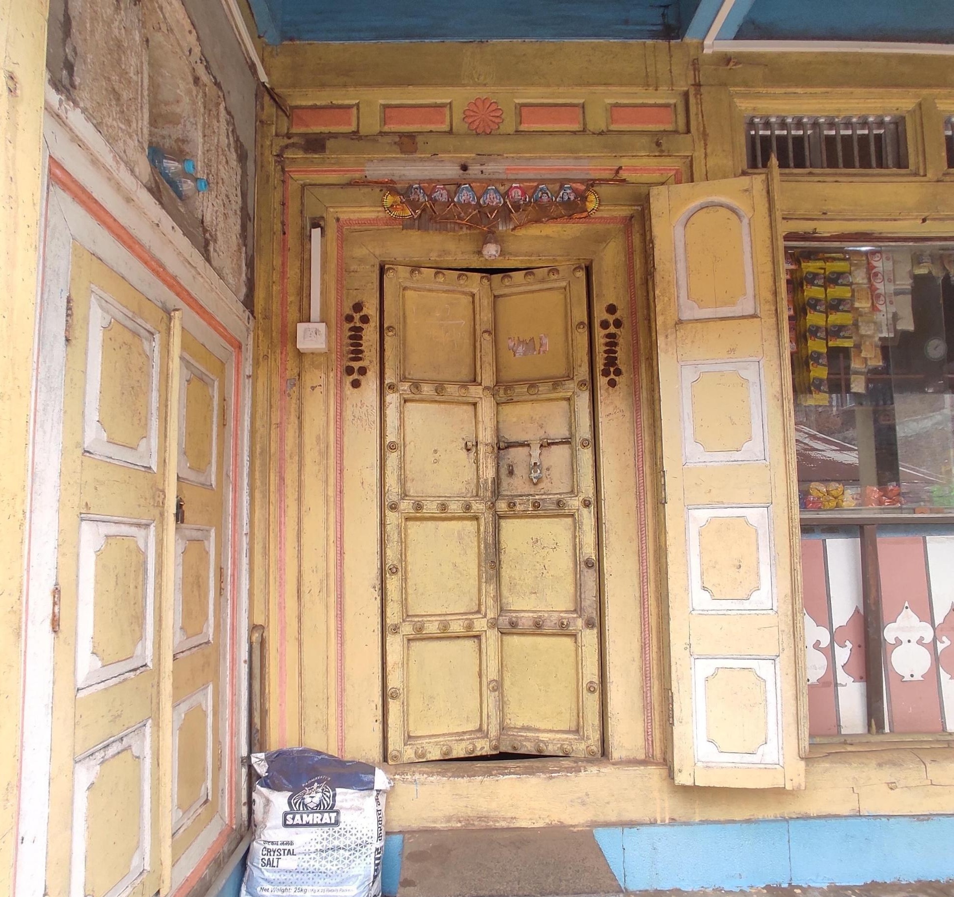Main entrance to the residence beside the shop. Decorative woodwork frames the door, and a torans hangs above.(Source: CKA Archives)