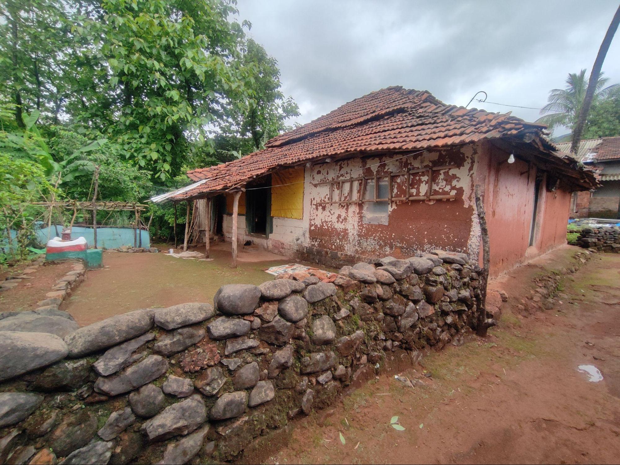 Built from local stone, the compound wall defines the house’s edge and anchors it to the site. (Source: CKA Archives)