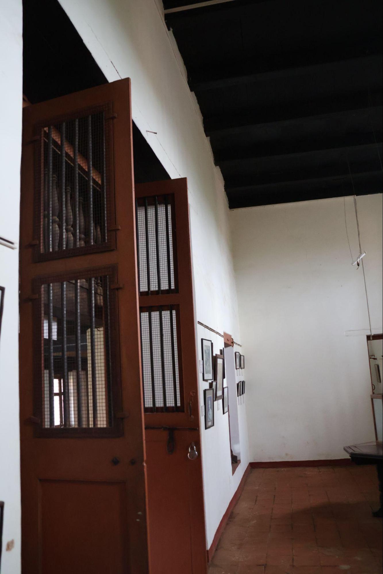 Wooden door with iron grills. Combines ventilation and safety, with a latch-and-bolt system and minimalist detailing. (Source: CKA Archives)