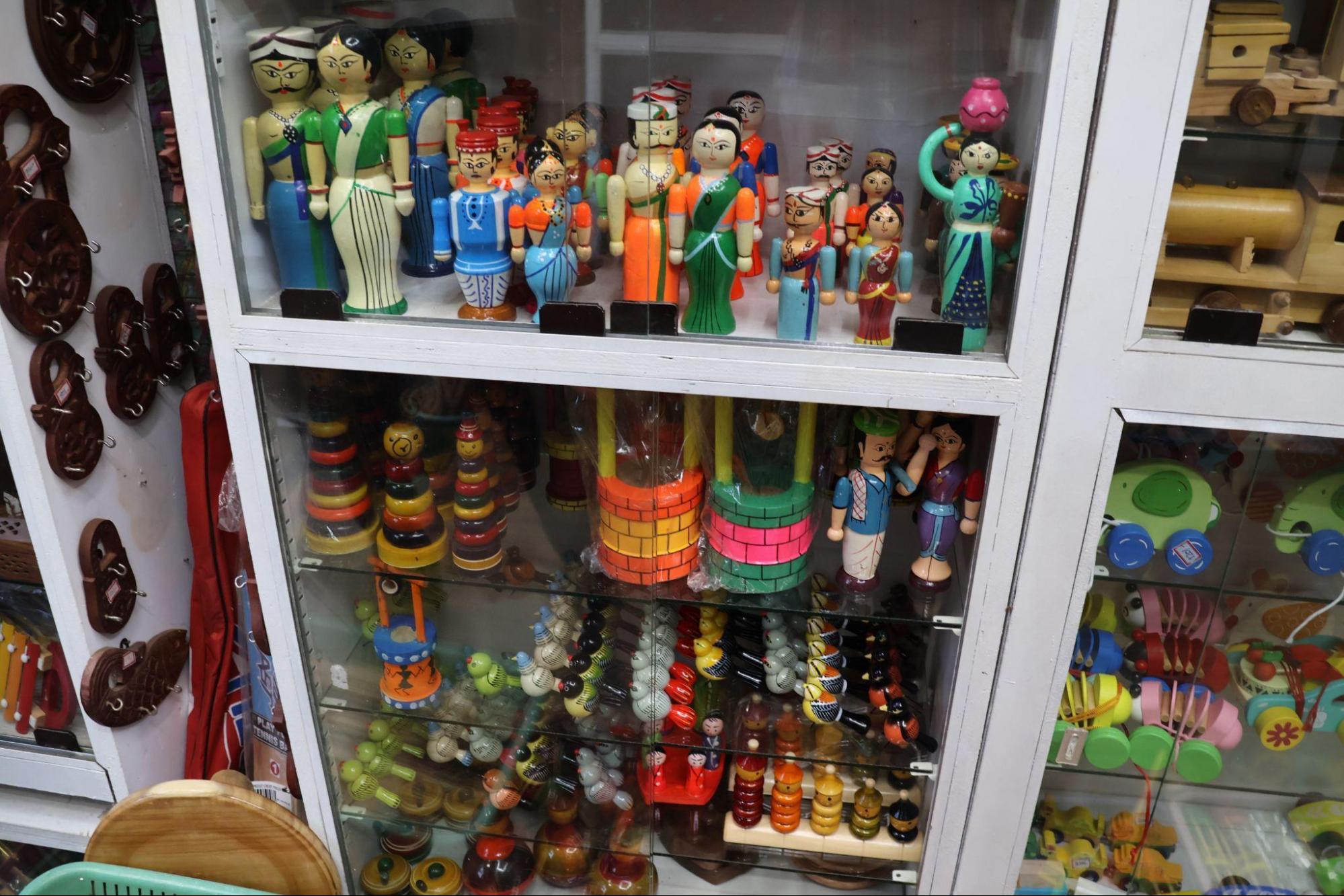 A colourful collection of traditional wooden toys and figurines, often seen in local markets across Maharashtra. These handcrafted pieces, painted in bright natural dyes, depict everyday village life, occupations, and characters (Source: CKA Archives).