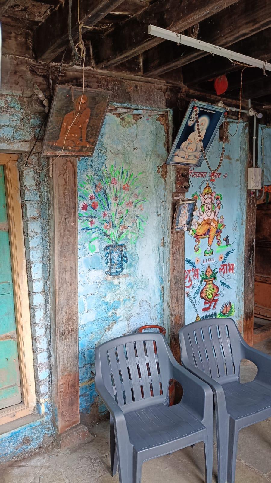 An extension to the courtyard featuring a seating area. Notice the colourful murals of Bhagwan Ganpati and a ‘kalash’ painted on the walls. Notice the pictures of Gajanan Maharaj hung on the wall. (Source: CKA Archives)