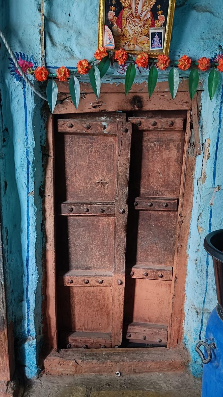 The kitchen door is made of double wood panels. Notice how a ‘toran’ (garland made using flowers and leaves) is hung on the door. (Source: CKA Archives)