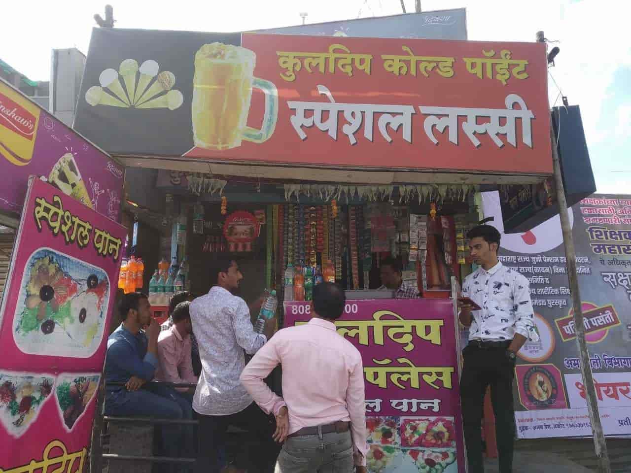 People gathered outside a cold drink shop in summer, with banners advertising lassi on display. (Source: CKA Archives)